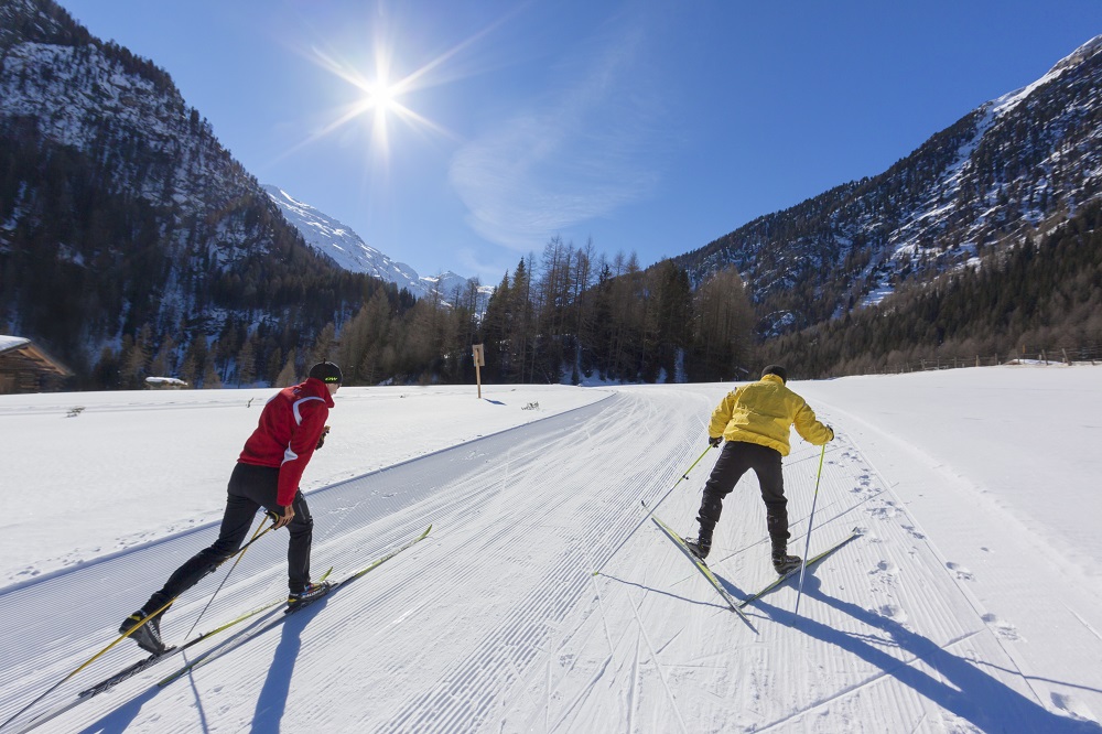 Langläufer auf Loipe im Vinschgau mit verschneitem Bergpanorama in Südtirol